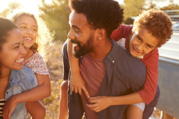 Parents giving their kids piggybacks, waist up, close up